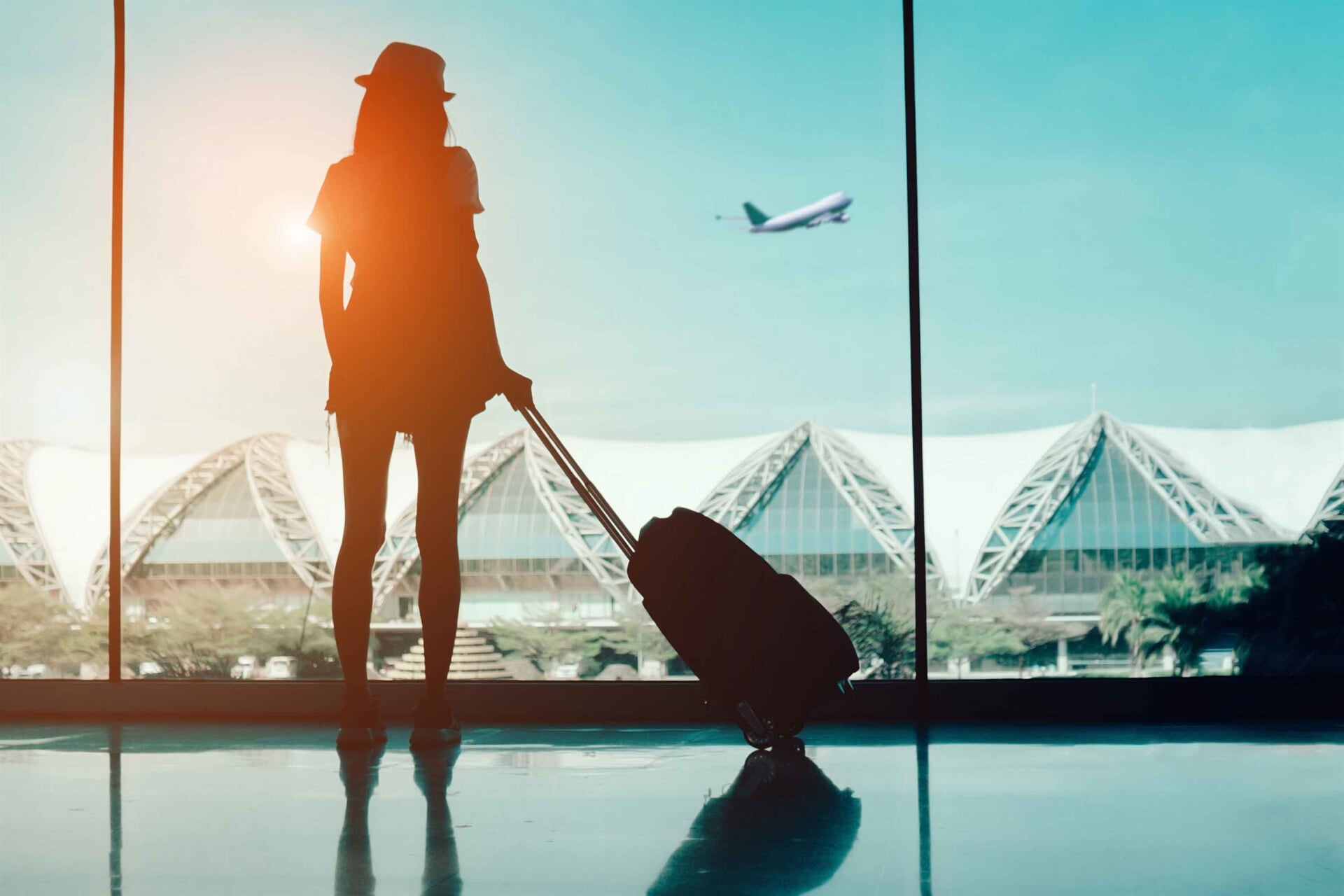 Traveller with a suitcase at an airport window